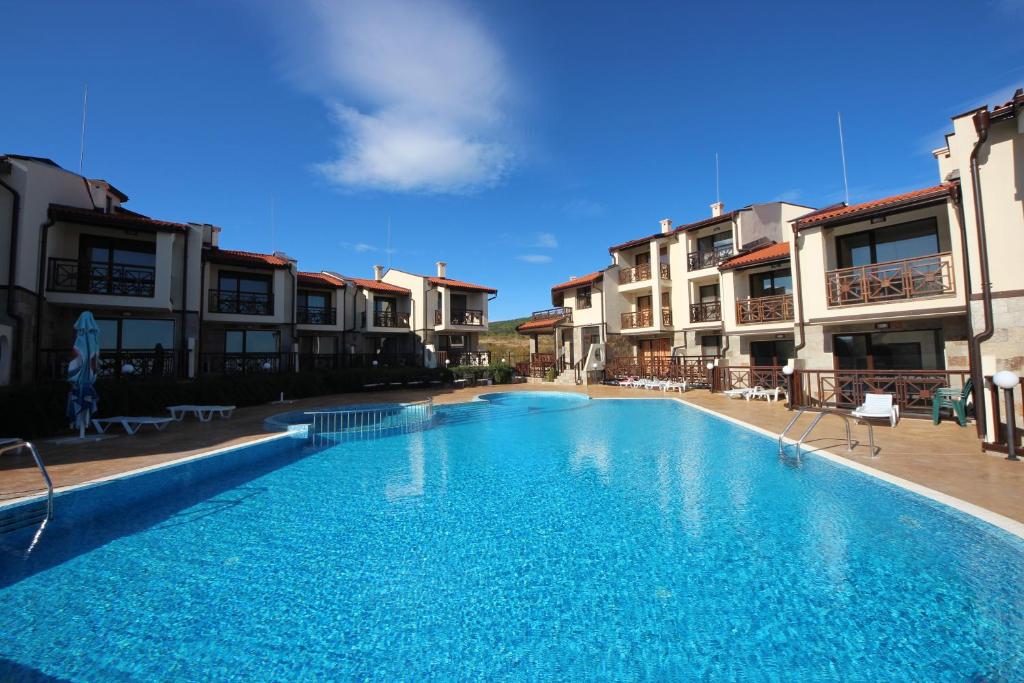 阳光海滩梅纳德御岭山庄酒店的一座大型游泳池,位于部分建筑前