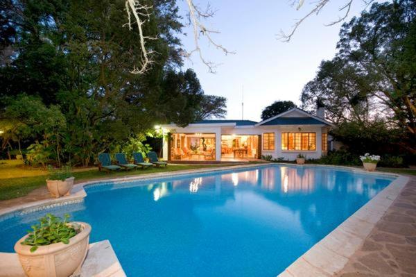 桑兰德Lupus Den Country House B&B的一座大蓝色游泳池,位于房子前