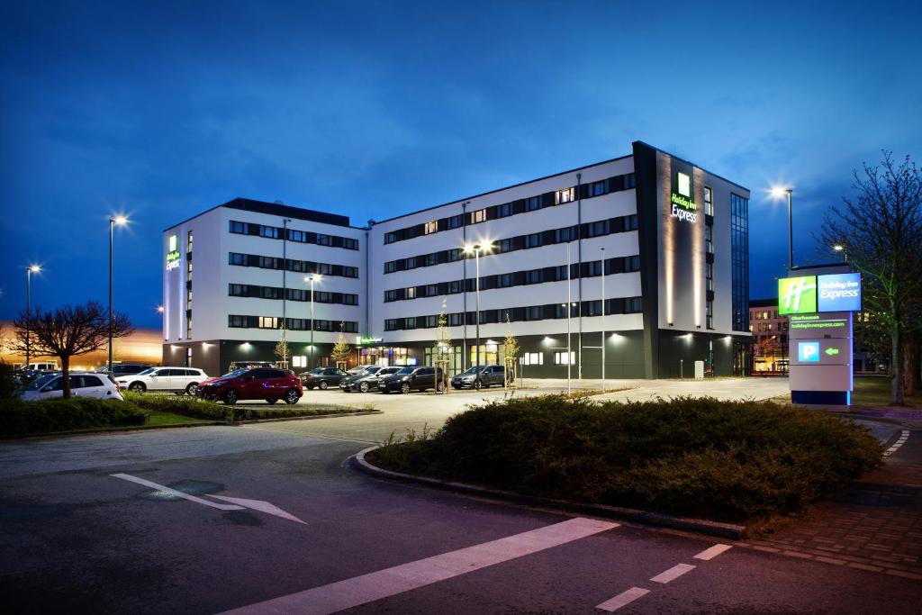 奥伯豪森Holiday Inn Express Oberhausen, an IHG Hotel的停车场里的一个大型建筑