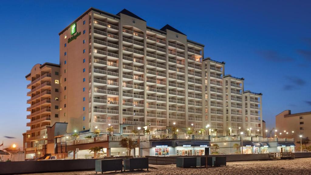大洋城Holiday Inn & Suites Ocean City, an IHG Hotel的一座大型建筑,在海滩上设有许多阳台