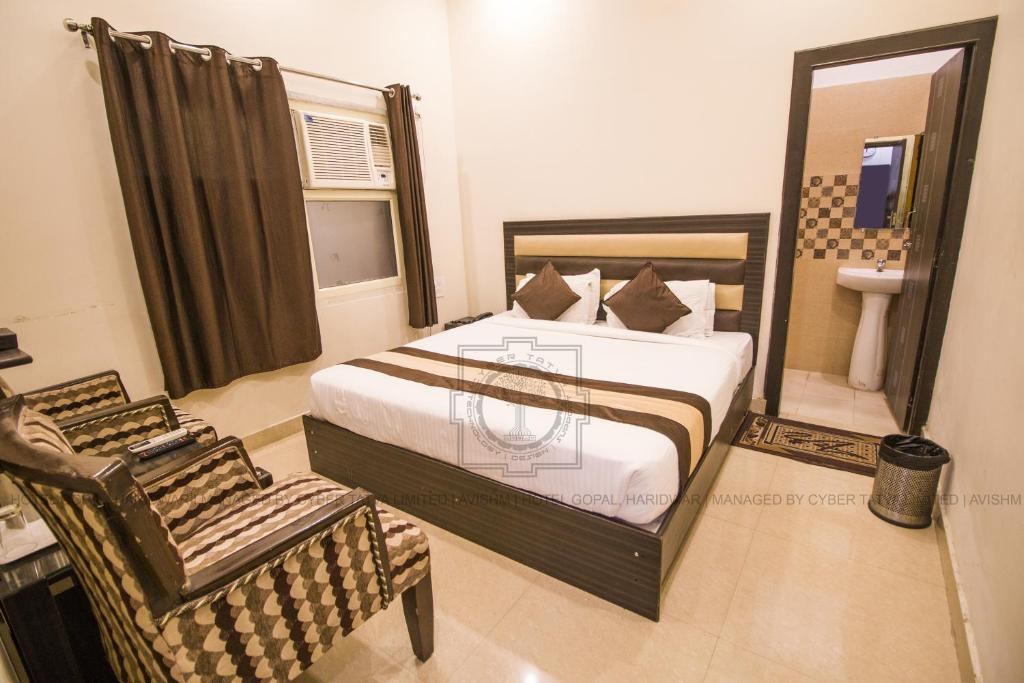 哈里瓦Hotel Gopal的一间卧室配有一张床、一把椅子和一个水槽