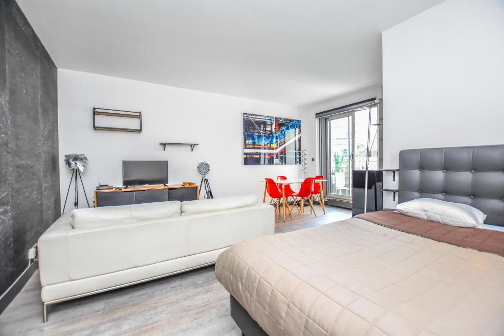 La VerrerieLuxe Neuilly s/ Seine的卧室配有白色大床和红色椅子