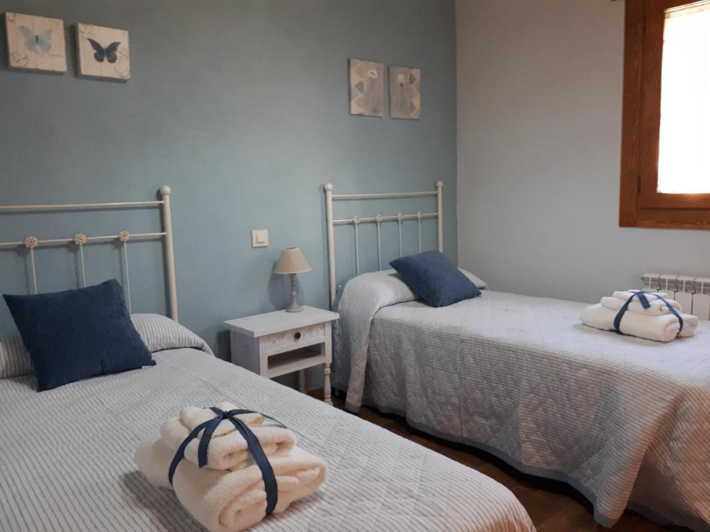 塞哥维亚La Zamarriega的一间卧室配有两张带毛巾的床