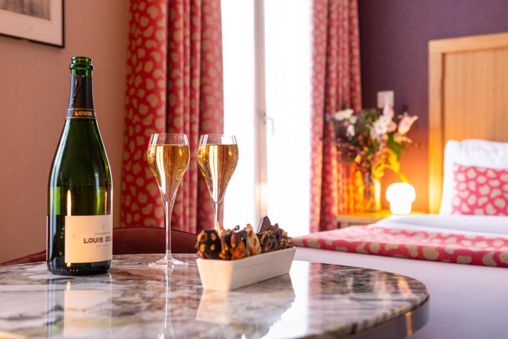 巴黎29乐匹克酒店的桌子上放有一瓶葡萄酒和两杯香槟酒