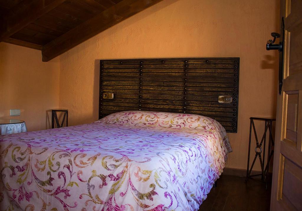 奥萨德蒙铁尔Casas Rurales con Jacuzzi Quijote y Sancho的一间卧室设有一张床和一个大窗户