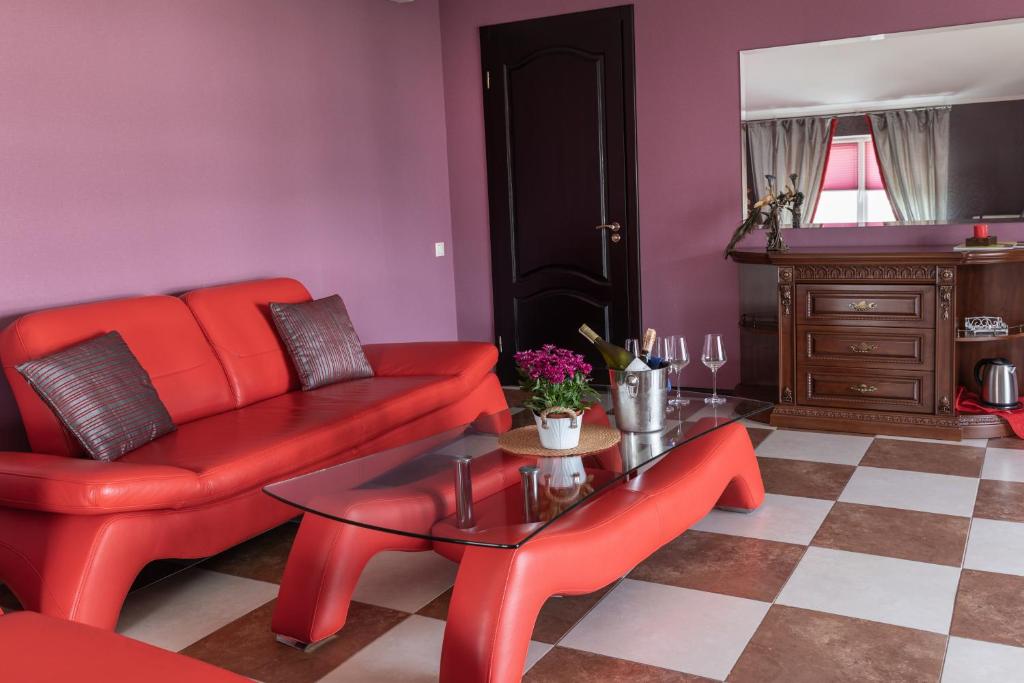 Zhukovtsy得卡奇奥夫宾馆的客厅配有红色的沙发和桌子