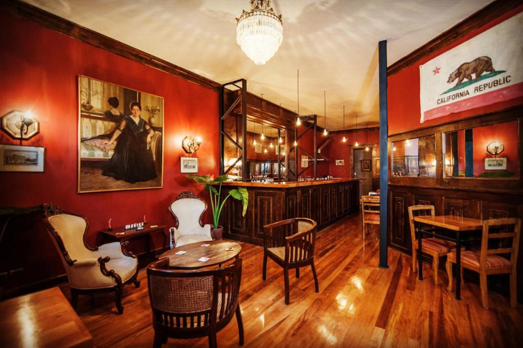 瓦尔帕莱索Casa California Guesthouse的餐厅拥有红色的墙壁和桌椅