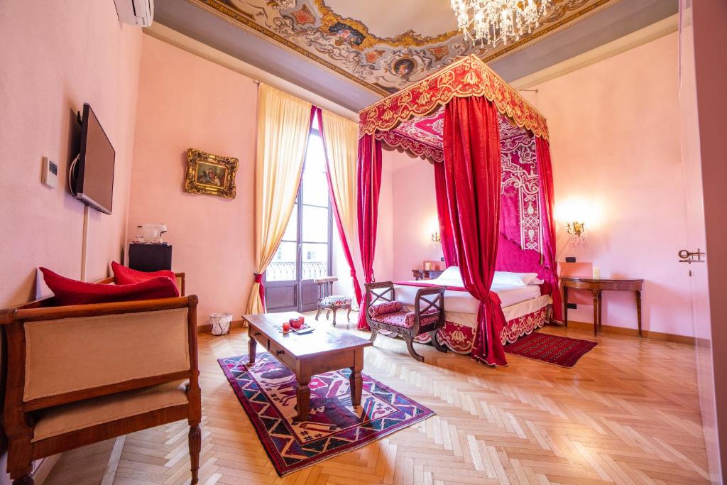 佛罗伦萨伽利略2000住宿加早餐酒店的一间卧室配有一张红色天蓬床