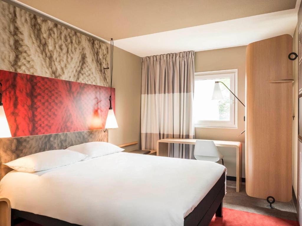 默伦默伦宜必思酒店的酒店客房设有一张大床和一张书桌。