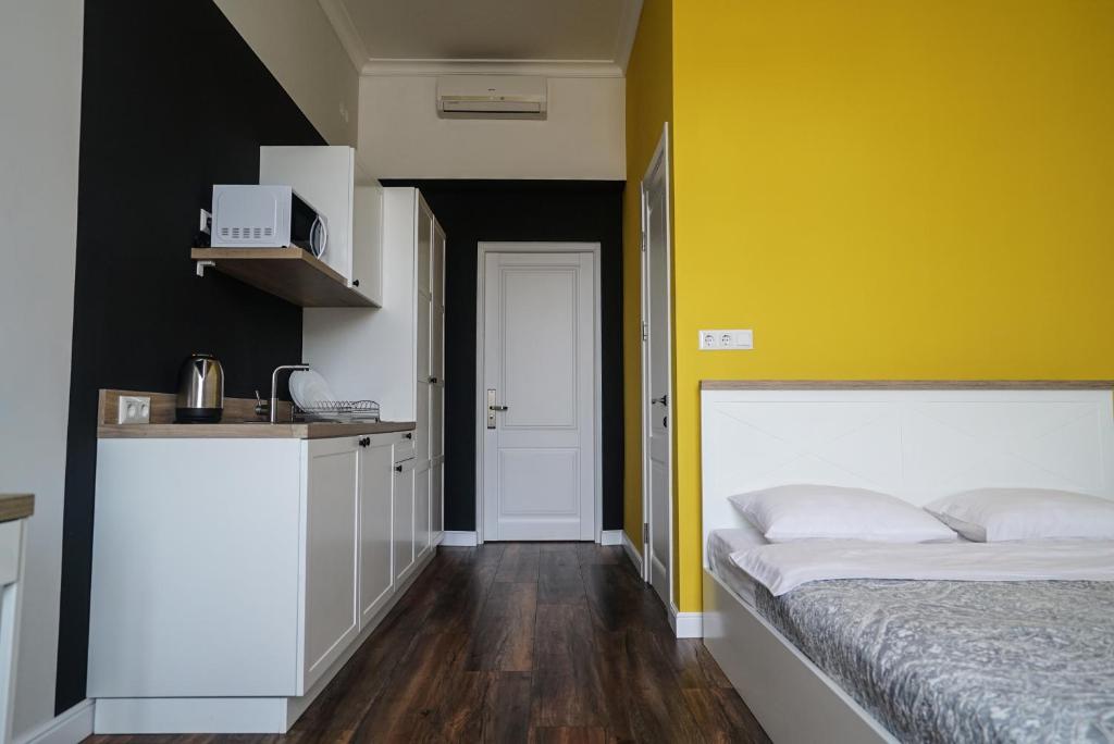 利沃夫HOTEL N°10的一间卧室设有一张床和黄色的墙壁