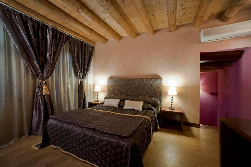 维罗纳卡萨麦格纳尼酒店的一间带床的卧室,位于带窗帘的房间