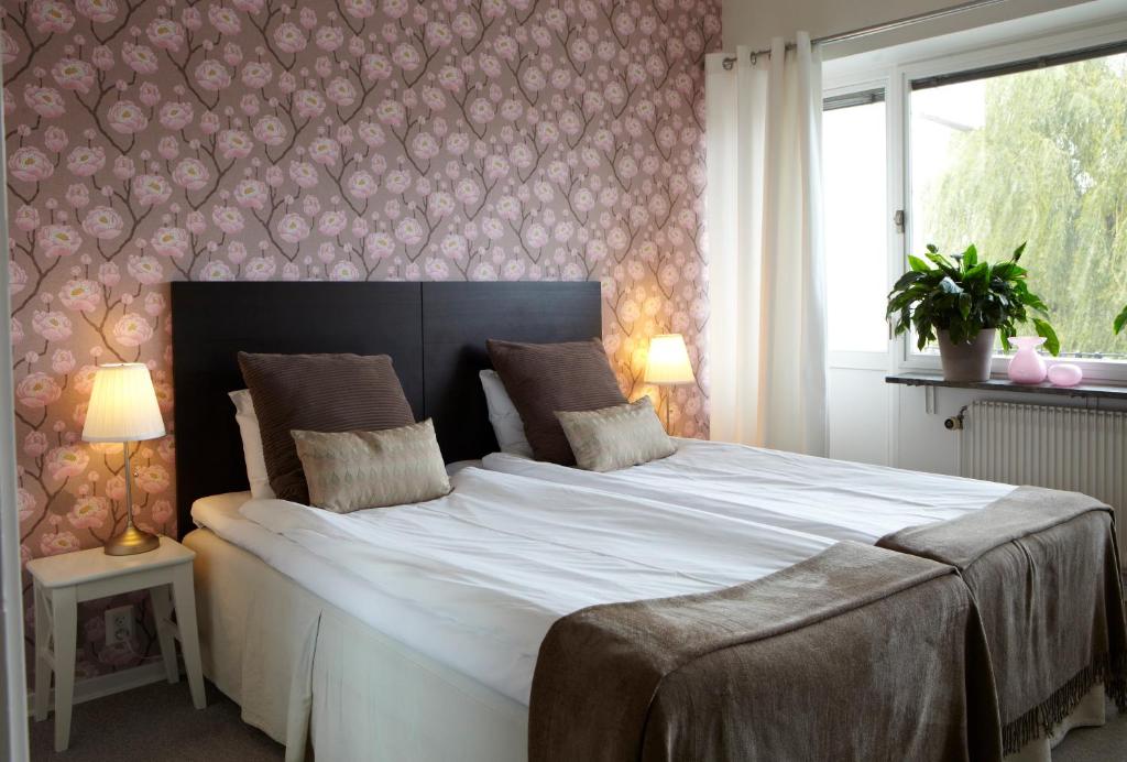 恩厄尔霍尔姆Riverside Hotel i Ängelholm的卧室内的一张大白色床,卧室内有墙壁