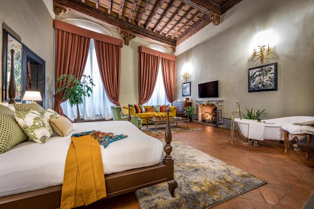 佛罗伦萨Palazzo Bianca Cappello Residenza d'Epoca的一间带一张床的卧室和一间带浴缸的客厅