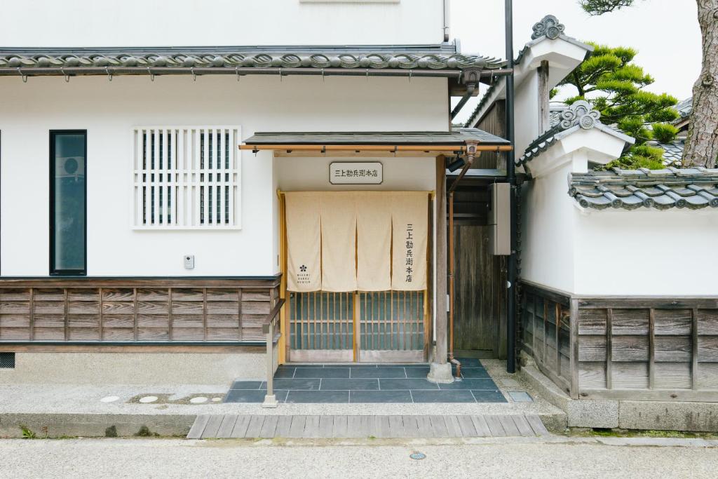 宫津市三上勘兵衛本店 Mikami Kanbe Honten的一座建筑,上面有门标