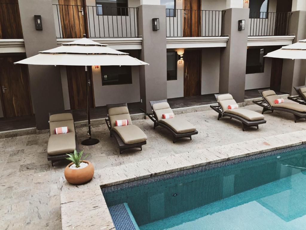 圣何塞德尔卡沃SIX TWO FOUR Urban Beach Hotel的游泳池旁设有躺椅和遮阳伞的游泳池