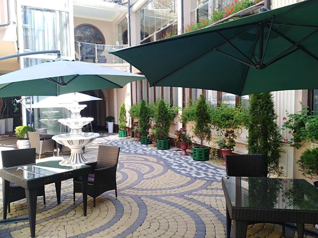 切尔诺夫策潘斯基蒂维尔酒店 的一座建筑中带桌子和遮阳伞的庭院