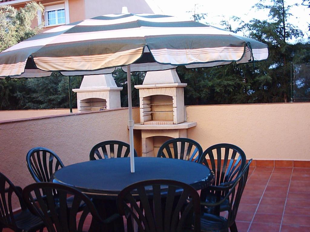 拉斯卡弗里亚Parque Sierra Norte的天井上配有蓝色桌椅和遮阳伞