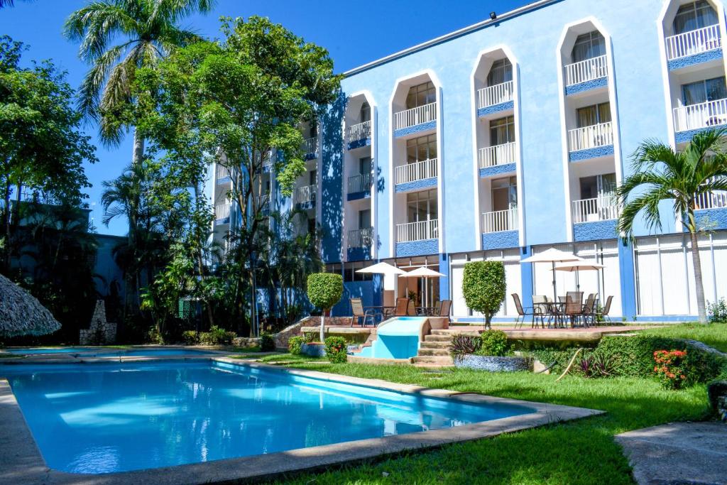 帕伦克Hotel Maya Palenque的大楼前的游泳池