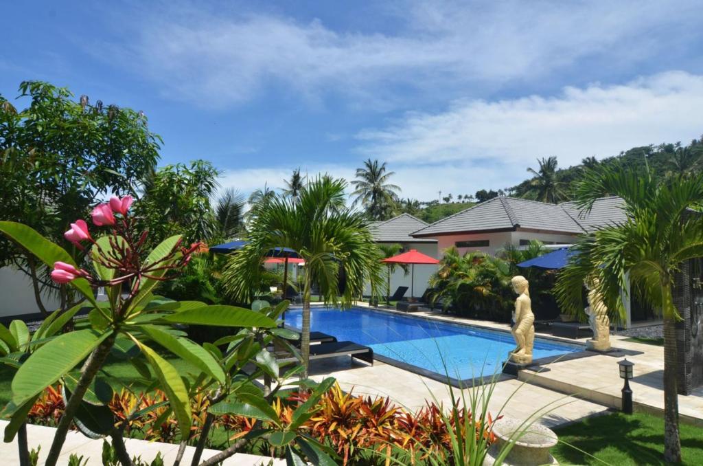 圣吉吉梦幻庄园度假酒店的棕榈树和房屋的度假游泳池