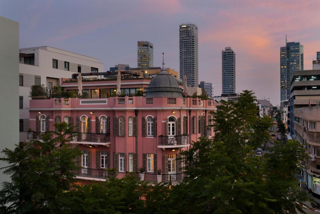 特拉维夫Hotel Nordoy的城市前的粉红色建筑