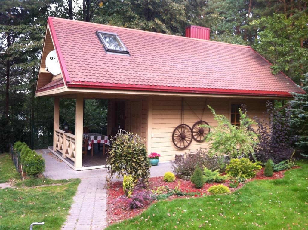 特拉凯蜂蜜浴度假屋的院子中一座红色屋顶的小房子