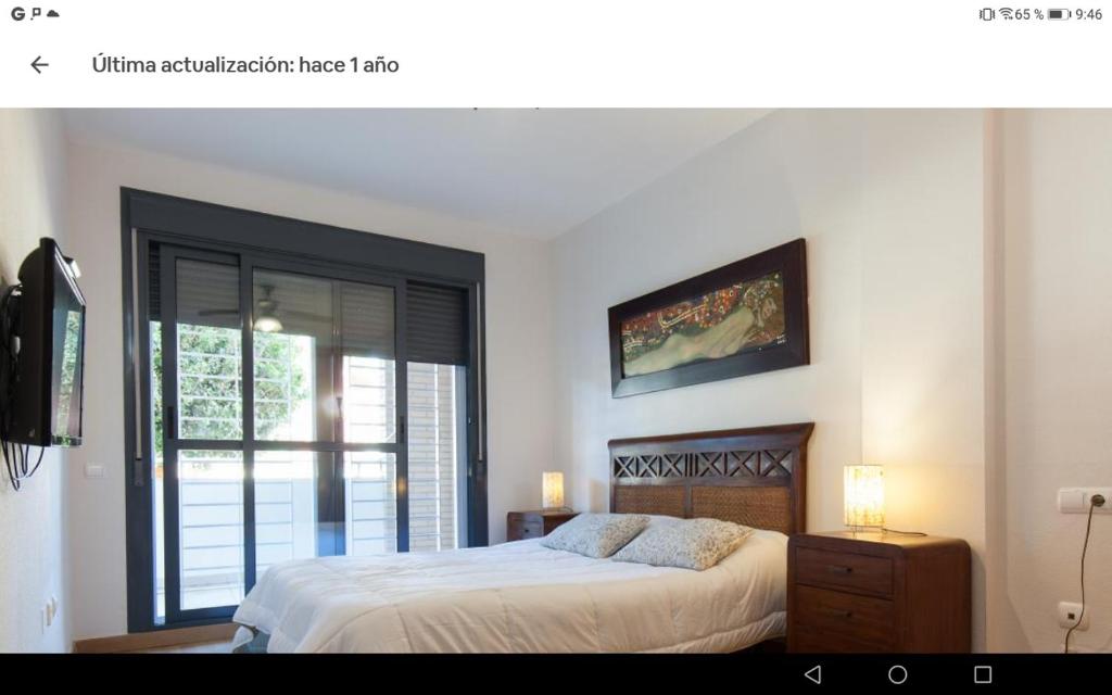 滨海罗克塔斯Calle Austria的一间卧室设有一张大床和一个窗户。