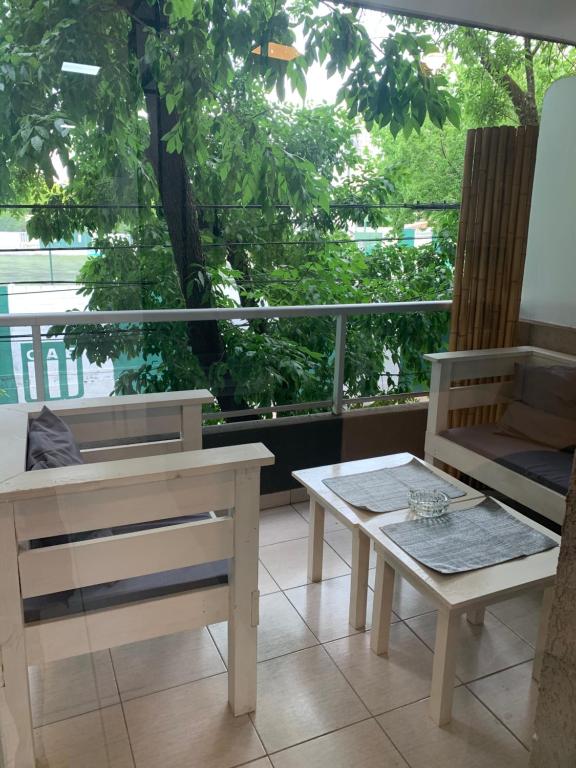 布宜诺斯艾利斯Belgrano Chic apartament的一间设有桌子、长凳和窗户的房间