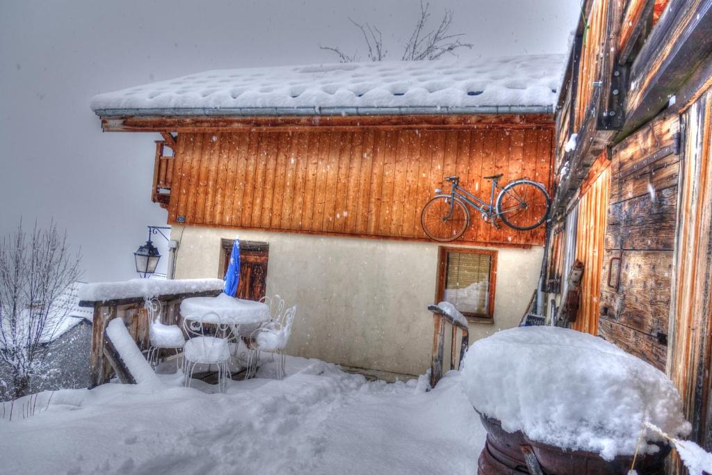 于埃petite maison à Huez的雪地屋顶上一辆自行车的房子