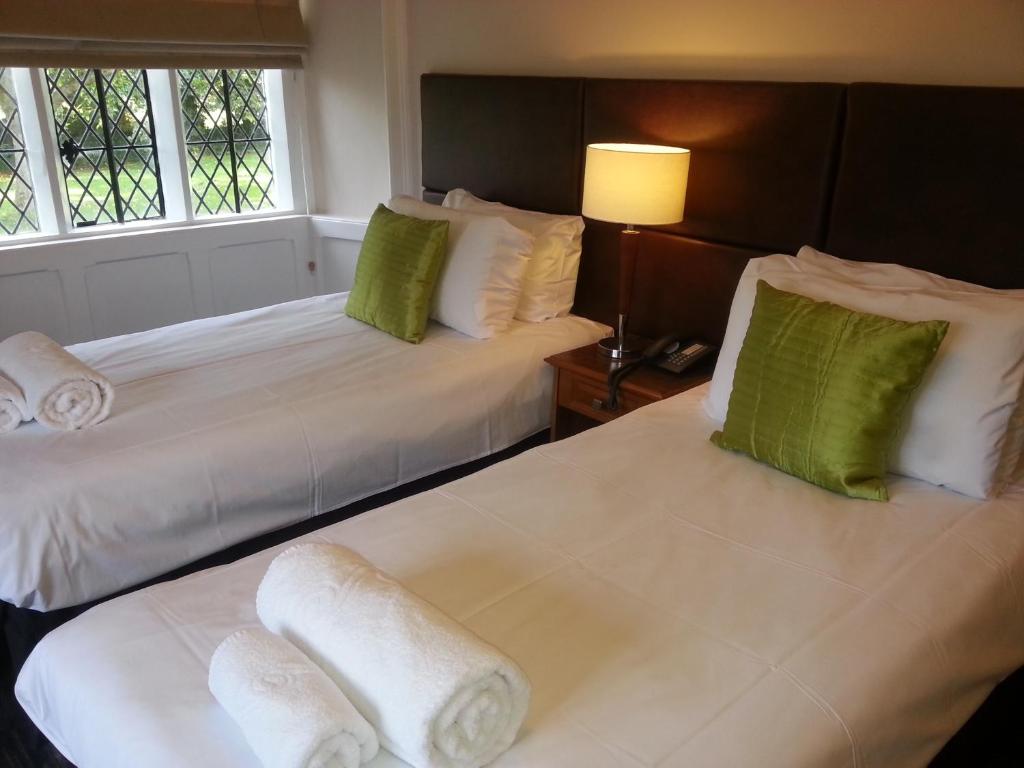 桑伯里桑伯里宾馆的配有两张床铺的酒店客房,提供绿色和白色枕头