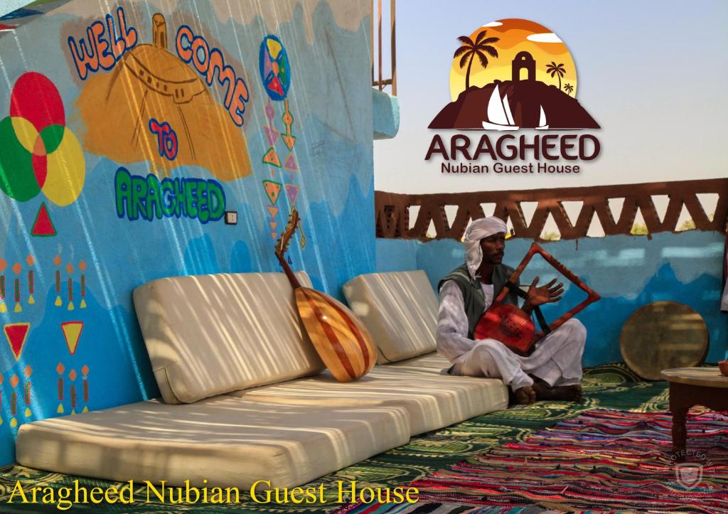 阿斯旺Nubian Kingdom Aragheed House的坐在舞台前沙发上的人