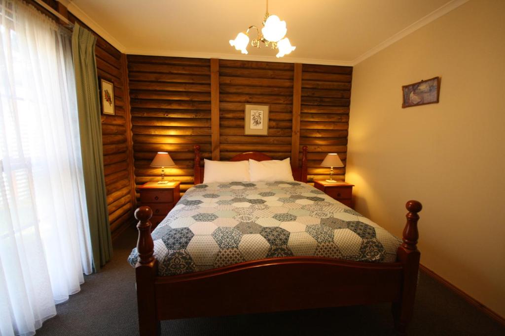 霍尔斯加普霍尔斯加普小屋度假酒店的一间卧室配有一张床、两盏灯和一个窗户。