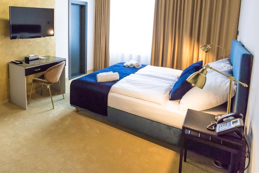 科希策Apart Hotel GOLDEN apartments的酒店客房配有一张带书桌的床和一张书桌