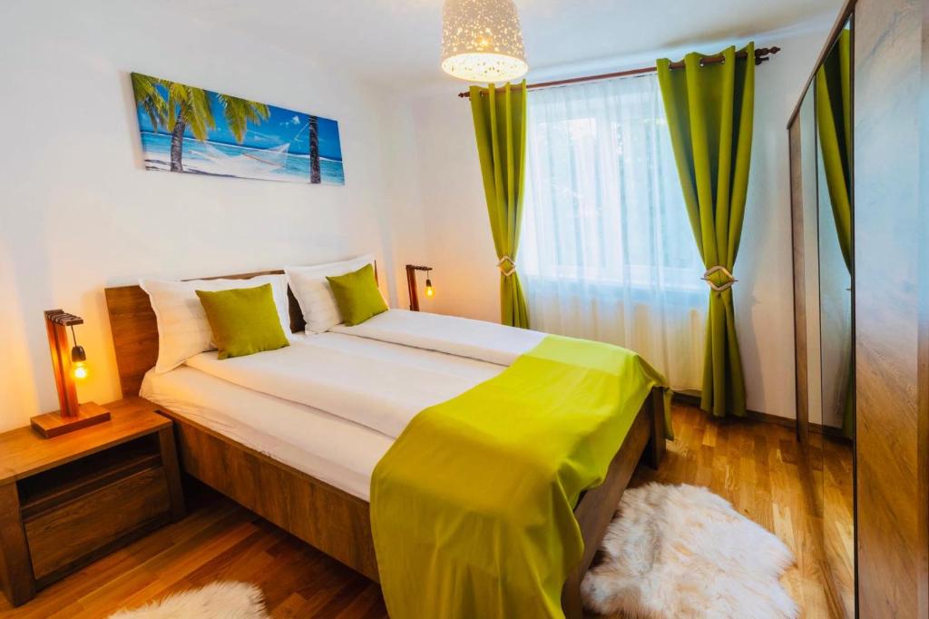 锡吉什瓦拉Relax Apartment 1的一间卧室配有一张带绿色床单的大床和窗户。