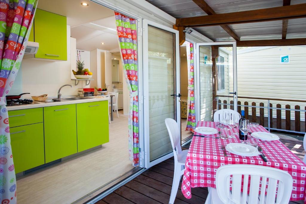 切齐纳码头Camping Village Mareblu的厨房以及带桌椅的用餐室。
