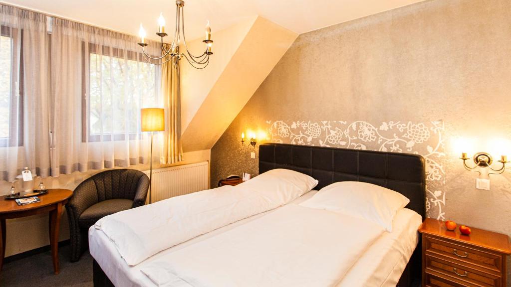 科隆豪斯英格鲍格艺术康福特酒店的一间卧室配有一张床、一张书桌和一个窗户。