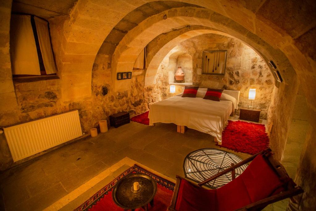 乌奇希萨尔Asmalı Cave House的石头间内一间卧室,配有一张床