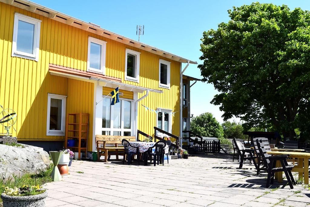 BjörköSolhem Bohus Björkö的前面设有桌椅的黄色建筑