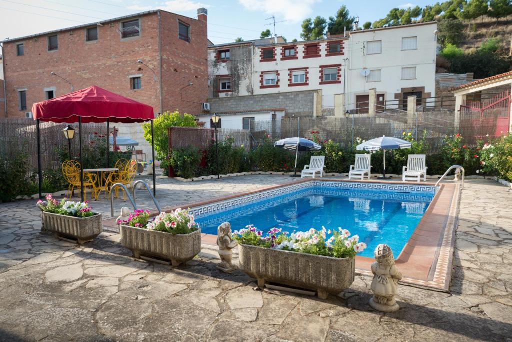 ClaravallsCal Carreró的一座游泳池,里面装有鲜花,放在建筑物旁边