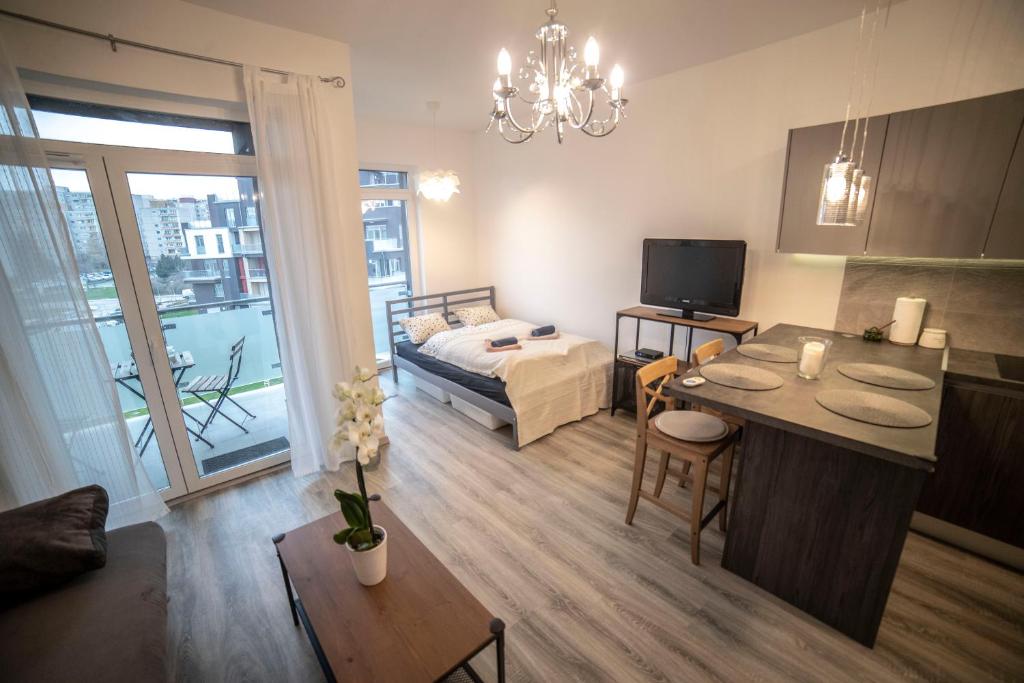 布达佩斯Sasadpark's new apartment in the west part of Buda的一间带一张床的客厅和一间带桌子的房间