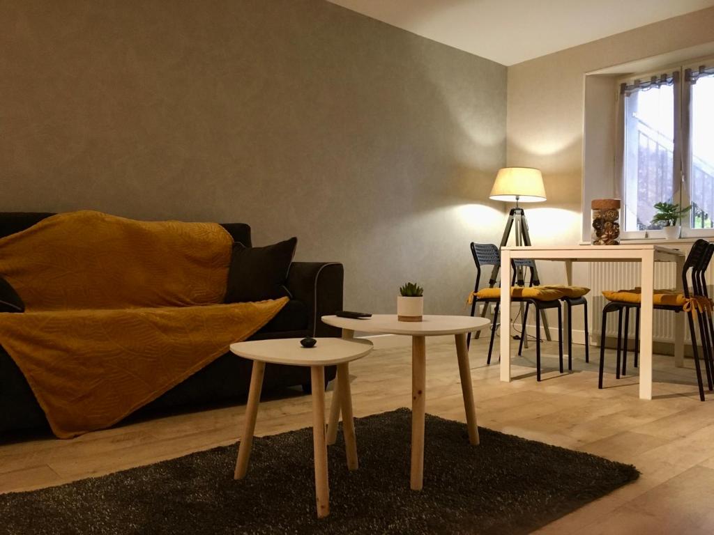 盖雷Appartement Guéret的客厅配有两张桌子和一张沙发