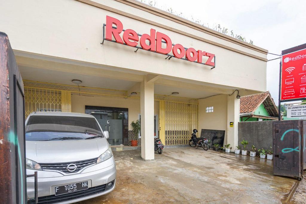 茂物RedDoorz Syariah near Exit Toll Ciawi的停在红书店前的白色汽车