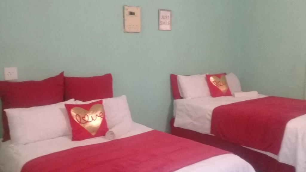 MogwaseRock of Rest的一间设有两张红色和白色床单的房间