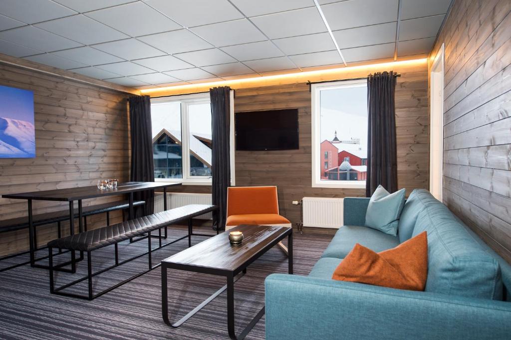 朗伊尔城Svalbard Hotell | Lodge的客厅配有沙发和桌子
