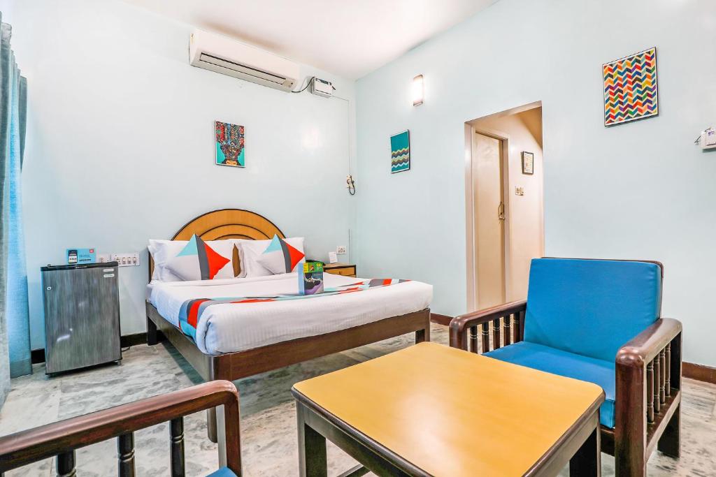 蓬蒂切里FabExpress Santhi Inn, Promenade Beach的配有一张床和一把椅子的酒店客房