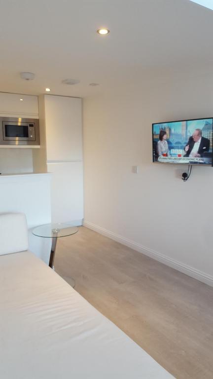 邓弗姆林Executive Annex - Dunfermline的一间设有桌子的房间和墙上的电视