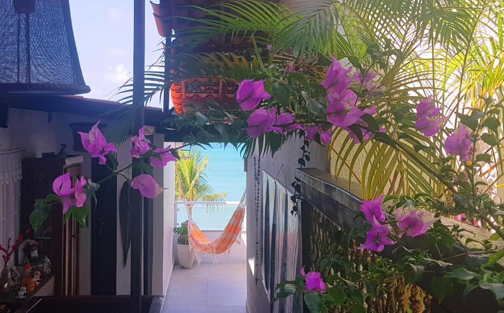 纳塔尔Pousada Recanto da Família的紫色花房享有海滩美景