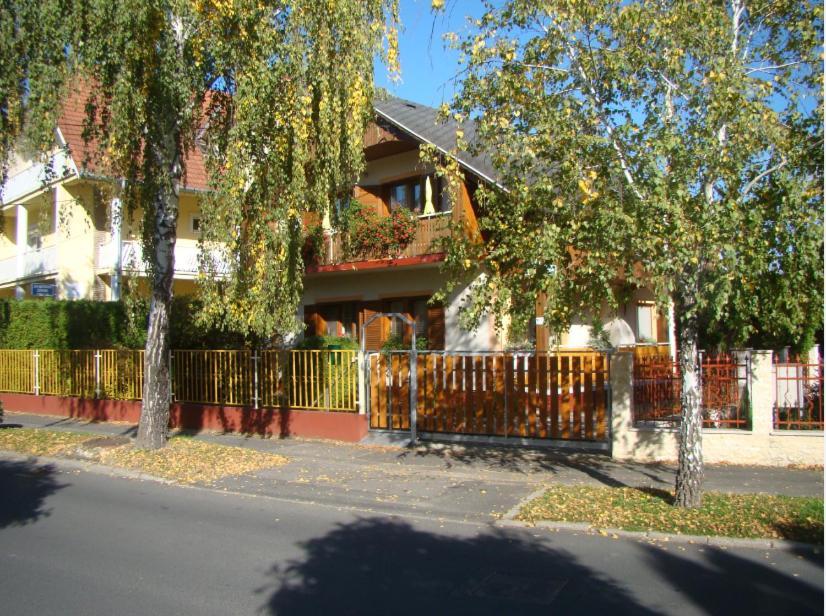 赫维兹Virágoskert Apartman的前面有栅栏和树木的房子