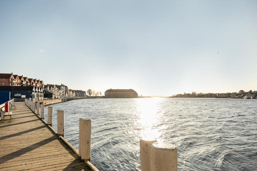 森讷堡Harbour Penthouse的水体上的码头,有建筑物