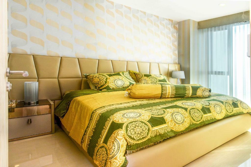 乔木提恩海滩LuxSL Luxury Style of Life 6的一间卧室配有一张黄色和绿色的床罩