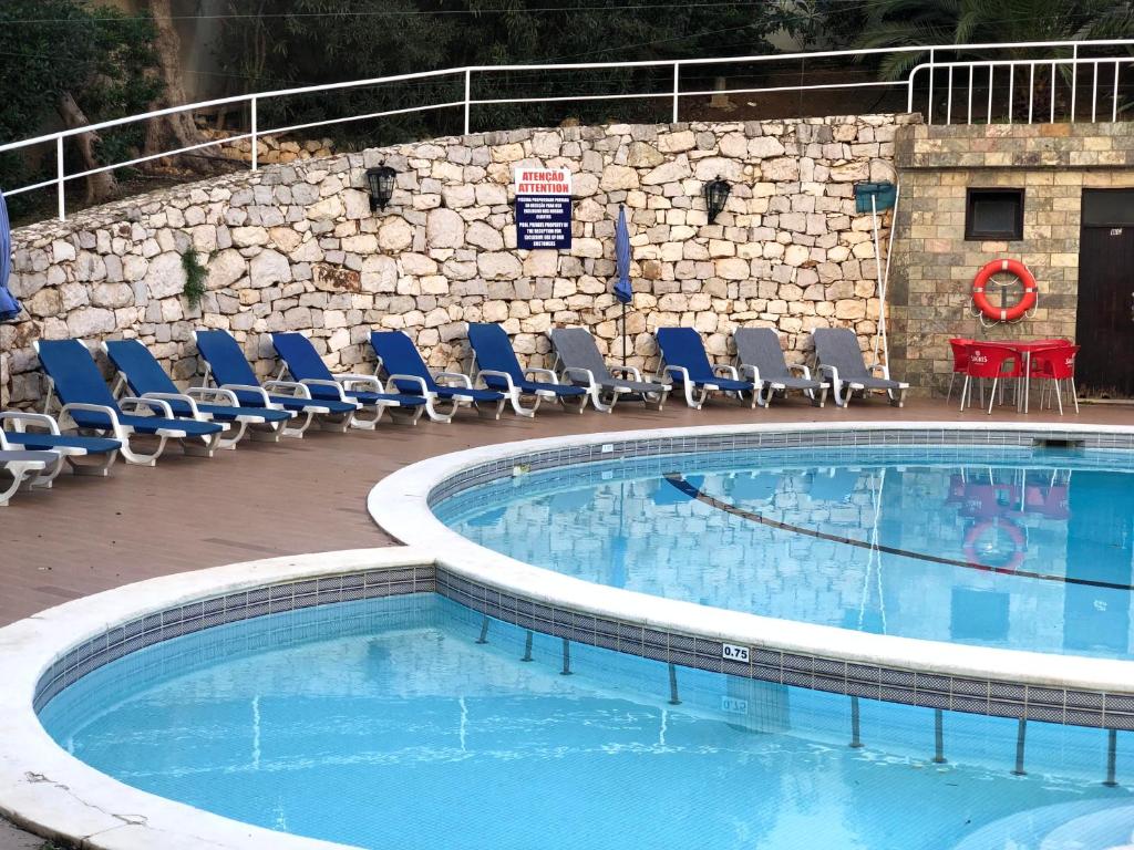 波尔蒂芒Squash Club Apartamentos的一个带椅子和桌子的大型游泳池